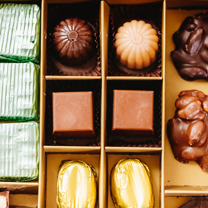 close up on Layla's delicacies valentine's gift box with pieces like Coconut Filling – Dark Cupola, Coconut Filling – White Cupola, Salted Caramel – Milky Cube, and Coffee Filling – Milky Bean